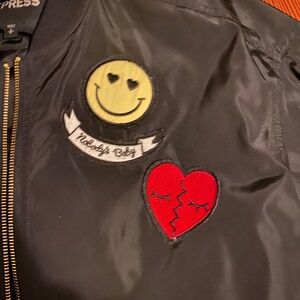 Black Nylon bomber jacket with lots of patches and shirring down the back.